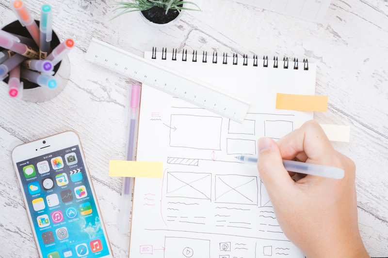 スマホ見ながら、今後の設計を描いている画像。